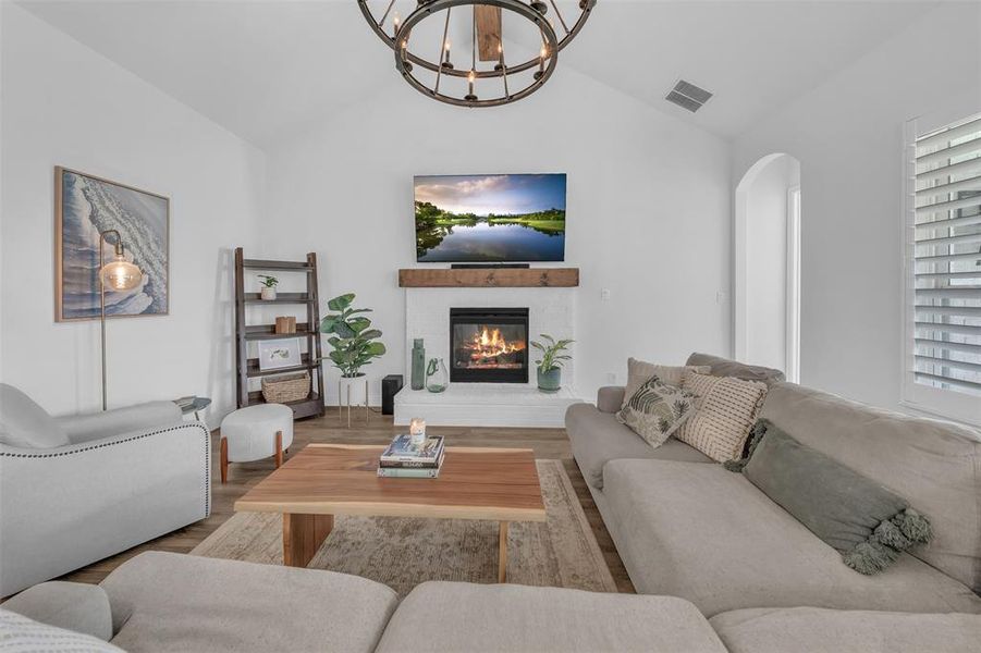 Living room with light hardwood / wood-style floors, a healthy amount of sunlight, and vaulted ceiling