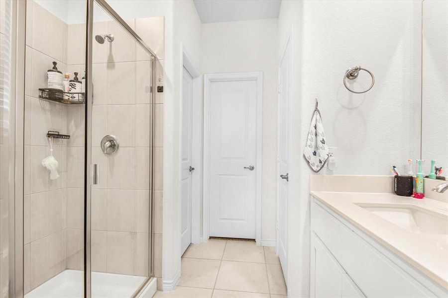 Bathroom with vanity, tile patterned floors, and an enclosed shower