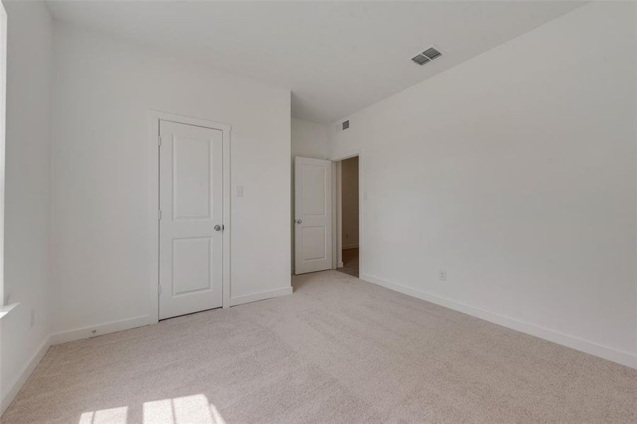 Unfurnished bedroom with light colored carpet