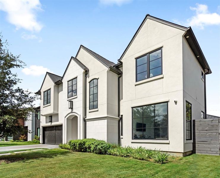 This modern masterpiece features a striking stucco and stone exterior with a sleek metal roof, creating a bold curb appeal. Zoned to the highly sought-after River Oaks Elementary, this home combines luxury and practicality with its clean lines, well-manicured lawn, and inviting entryway.