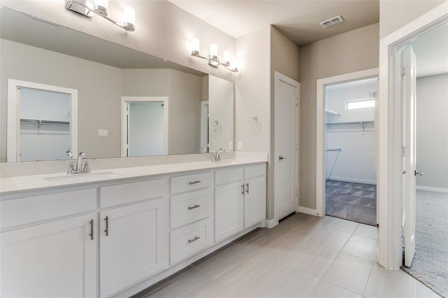 Bathroom featuring tile patterned floors and dual bowl vanity