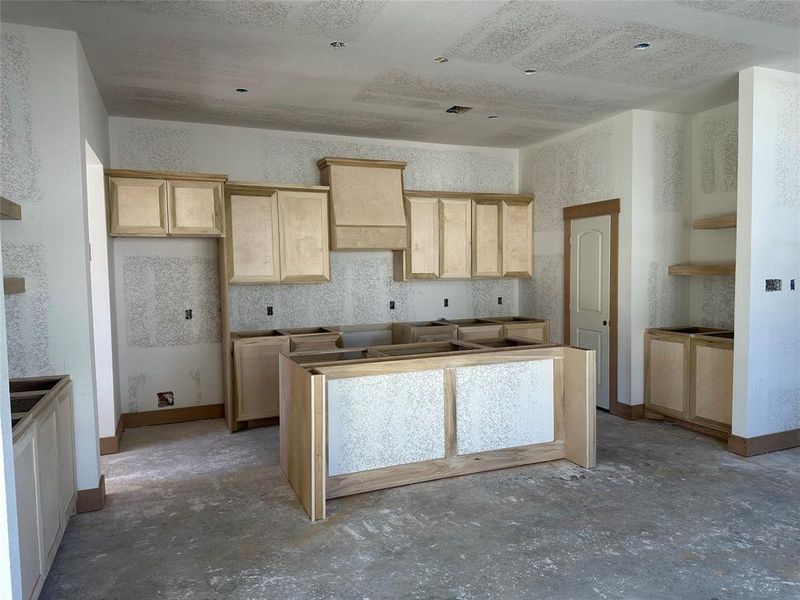 Custom carpentry in the kitchen! Fully equipped with a 7 foot island, custom venthood, beverage station and decorative exposed shelving.