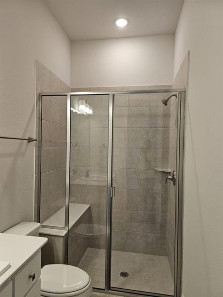 Bathroom with walk in shower, vanity, and toilet