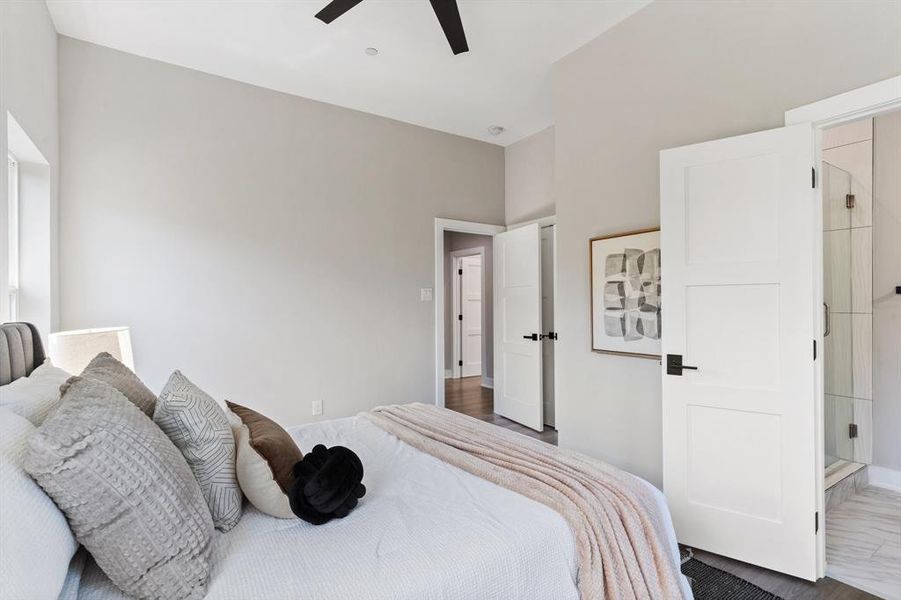 Bedroom featuring dark hardwood / wood-style flooring, connected bathroom, and ceiling fan