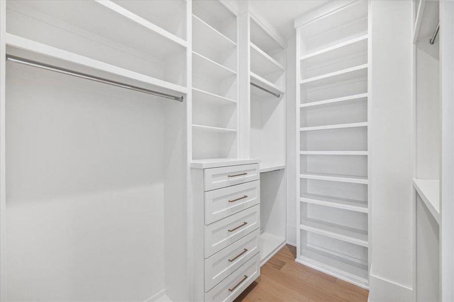 PRIMARY CLOSET #2: Ample space stretches before you, offering endless possibilities for organizing and displaying your clothing and accessories.