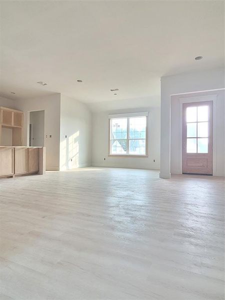 Unfurnished living room with a healthy amount of sunlight and light wood-type flooring