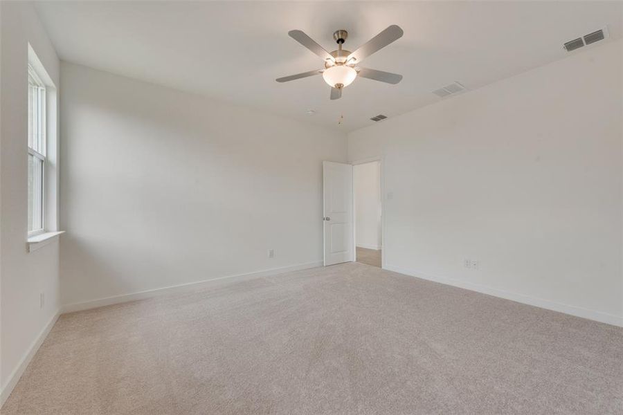 Carpeted spare room featuring ceiling fan