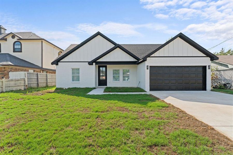 View of front facade with a garage and a front lawn