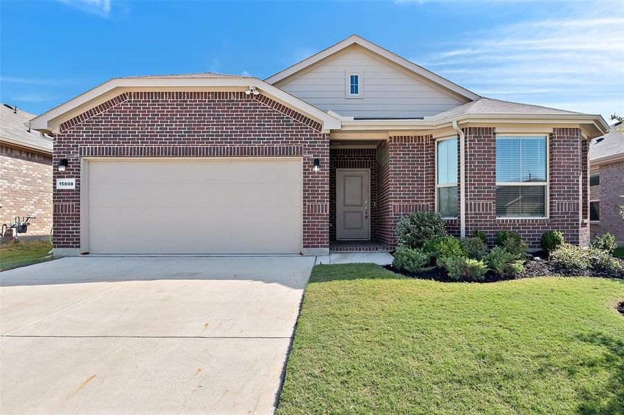 View of front of home with a front yard and a garage