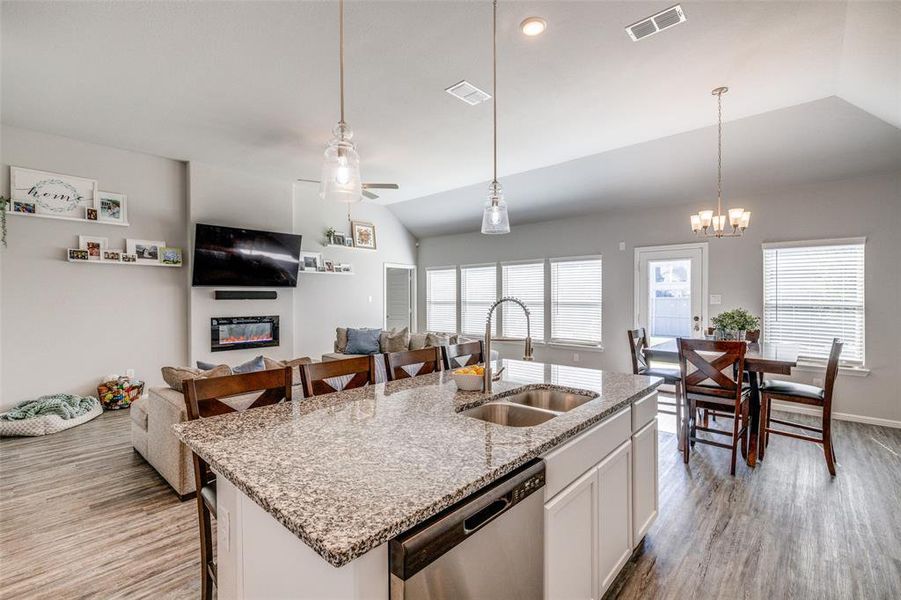 Kitchen featuring white cabinets, a center island with sink, stainless steel dishwasher, and sink