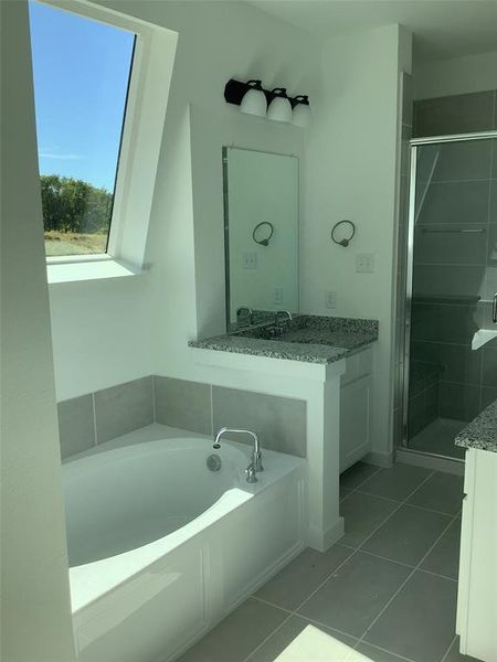 Bathroom featuring vanity, shower with separate bathtub, and tile patterned flooring