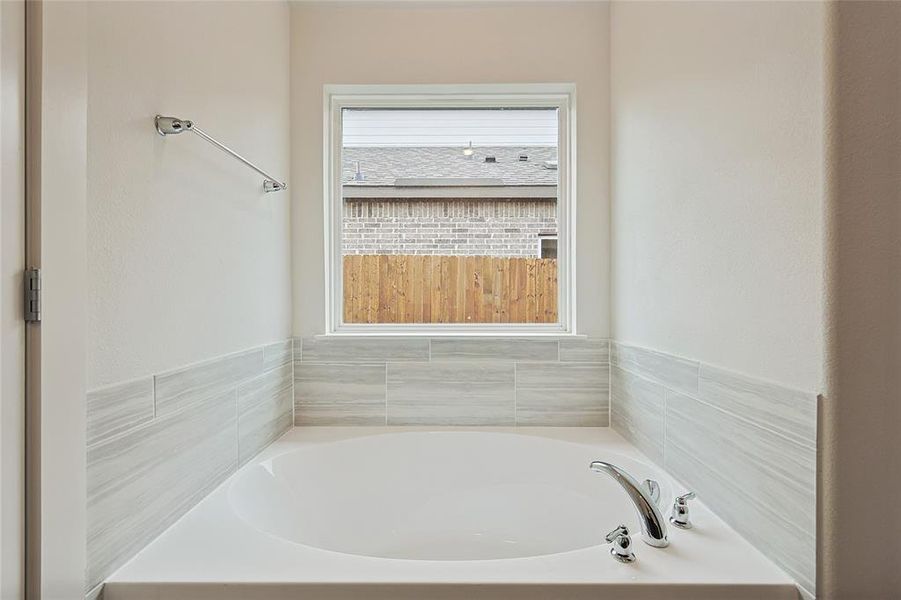 Bathroom featuring a tub and a healthy amount of sunlight