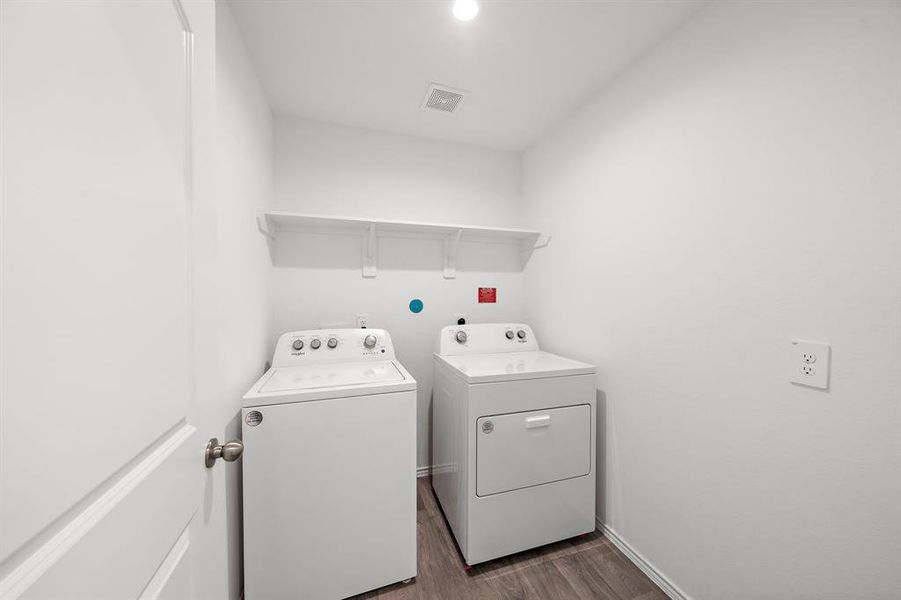 Utility room is tucked away around the corner from the living room. Comes with full size washer and dryer.