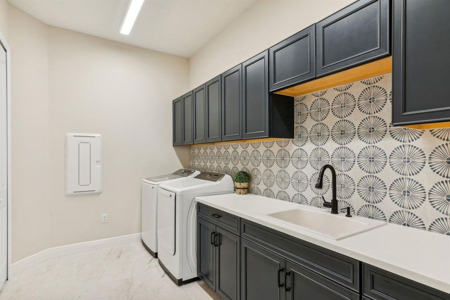 Large Laundry Room with cabinetry and tile backsplash