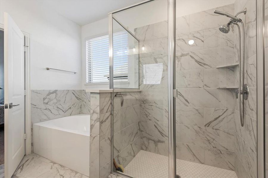 Bathroom featuring shower with separate bathtub and tile walls