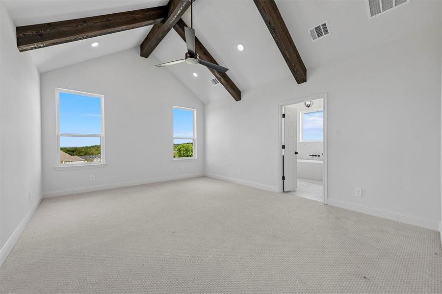 Unfurnished room featuring beamed ceiling, high vaulted ceiling, carpet flooring, and ceiling fan