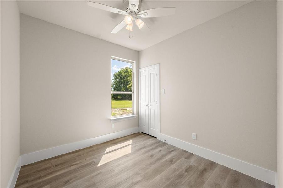 Unfurnished room with light wood-type flooring and ceiling fan