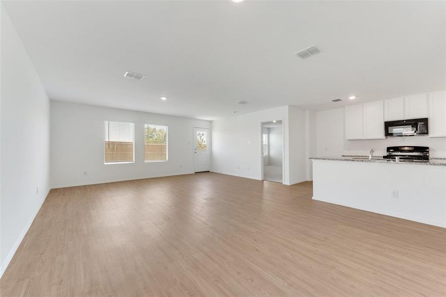 Unfurnished living room featuring light hardwood / wood-style flooring and sink