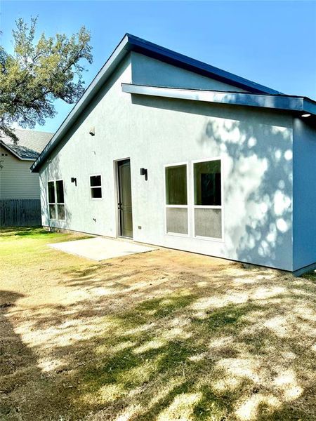 Rear view of property featuring a yard and a patio area