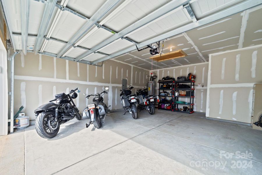 Drywalled garage!  Don't always find that these days! Good for sound and weather insulation! Central garage door for ease of operation, inset area in back for storage and extra depth.  EXTRA: Pull down stair lead to EXTRA attic storage not on all models.  Spacious and convenient!!