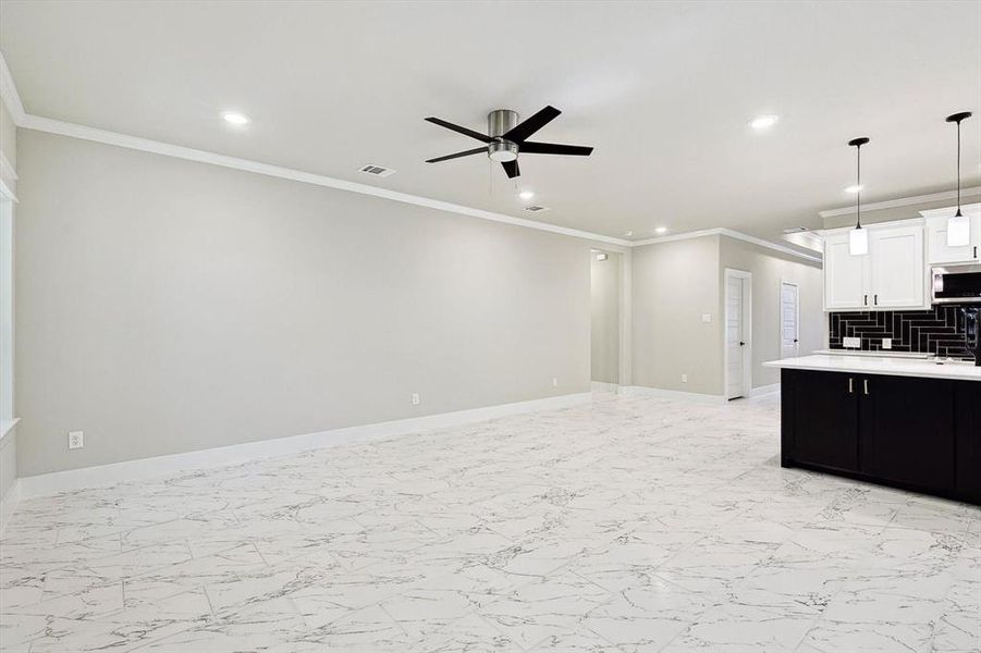 Kitchen with white cabinets, tasteful backsplash, light tile flooring, and ceiling fan