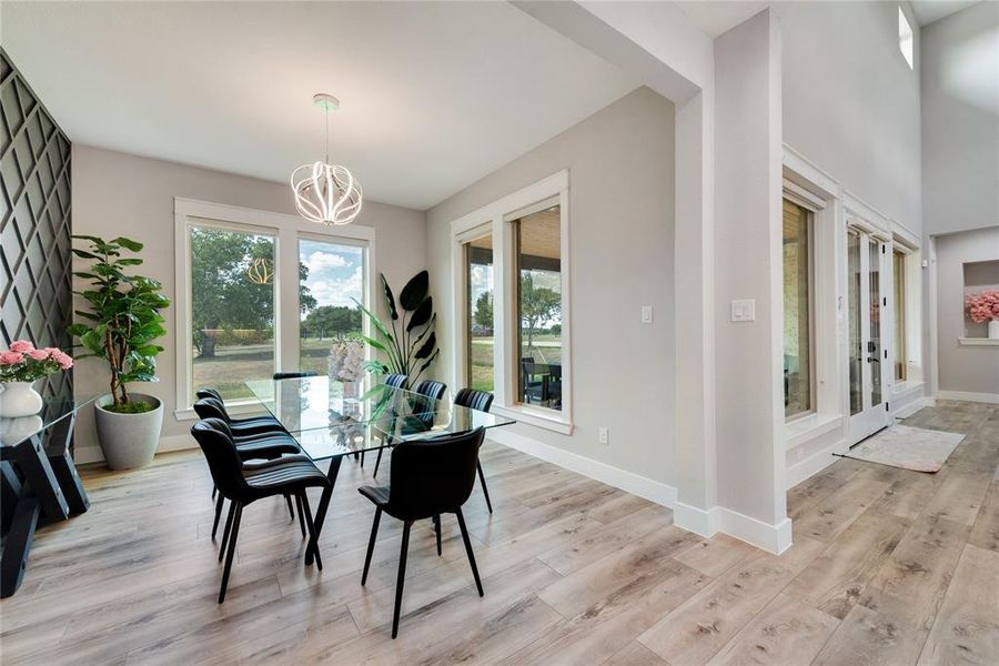 Dining space with light hardwood / wood-style flooring and a notable chandelier