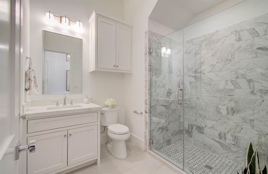 Full bathroom located on the first floor offers a walk in shower with a glass door. Beautiful tile and lighting.