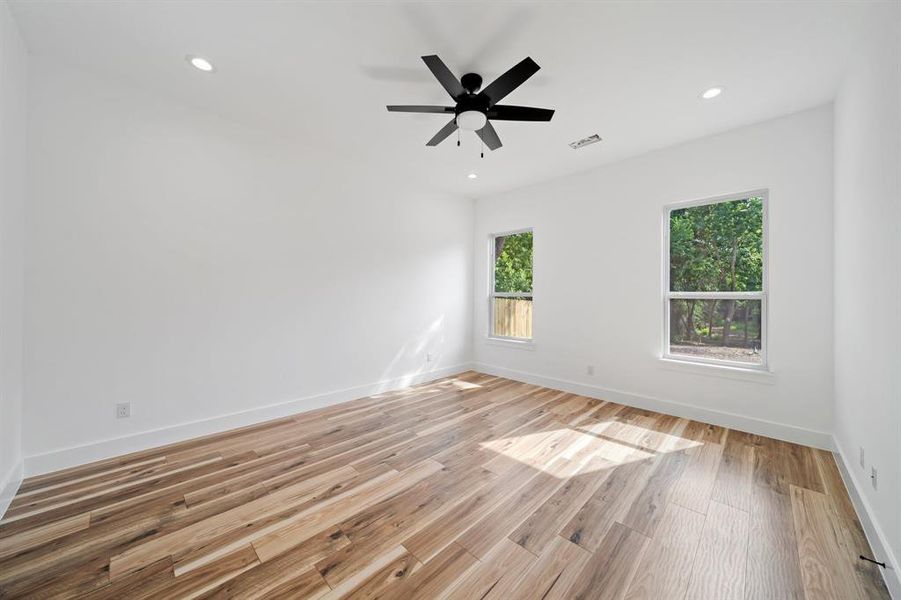 Empty room with light hardwood / wood-style flooring and ceiling fan