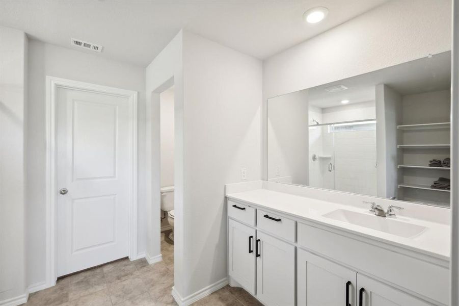 Bathroom with vanity, tile patterned flooring, toilet, and an enclosed shower