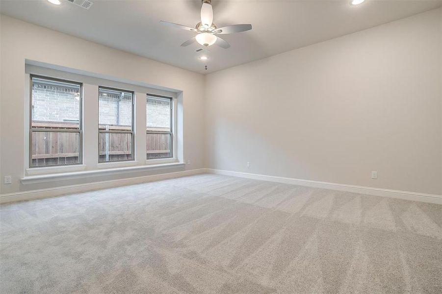 Empty room featuring ceiling fan and light colored carpet