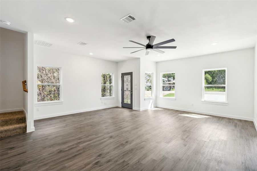 Unfurnished living room featuring dark hardwood / wood-style floors and ceiling fan