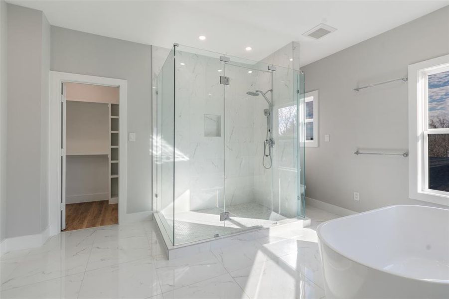 Bathroom featuring independent shower and bath and a wealth of natural light