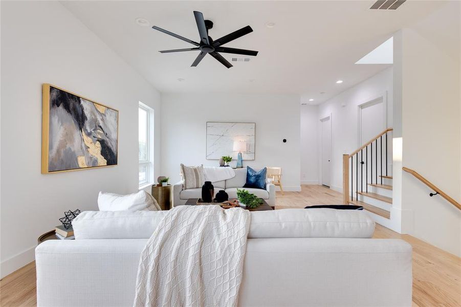 Living room featuring ceiling fan and light wood-type flooring