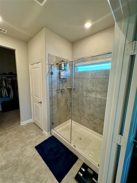 Bathroom with tile patterned flooring and a shower with shower door