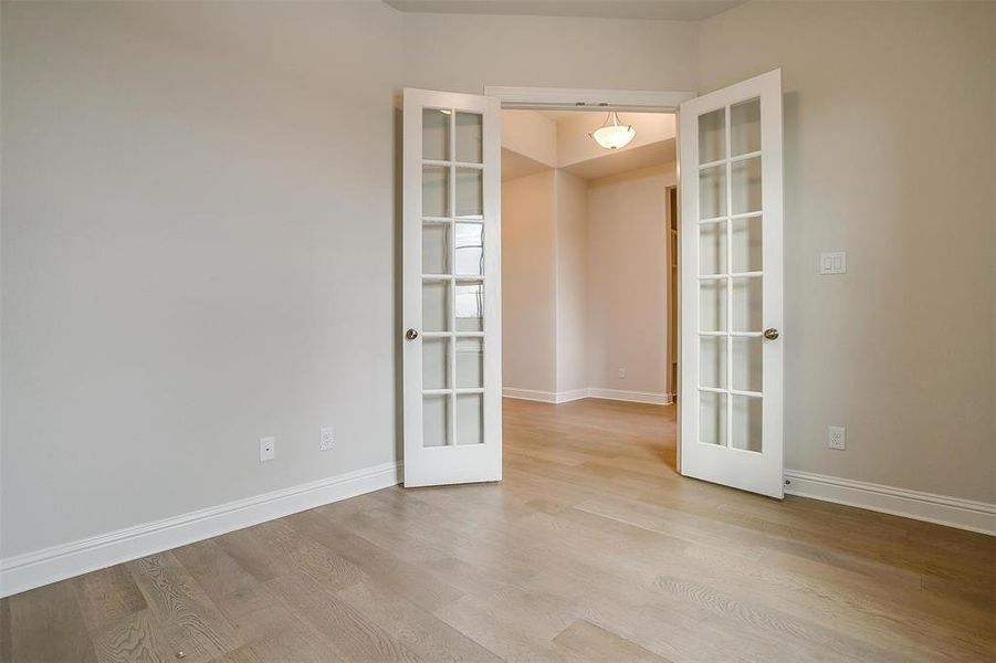 Spare room with light hardwood / wood-style floors and french doors