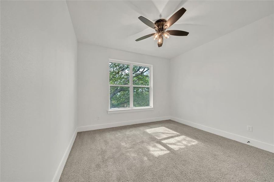 Unfurnished room featuring ceiling fan and light colored carpet