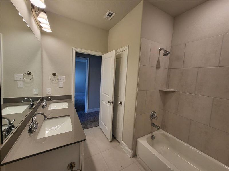 Bathroom with tile patterned flooring, vanity, and tiled shower / bath combo