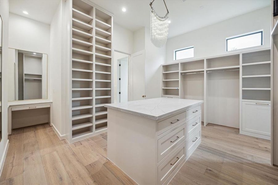 This expansive walk-in closet is a fashion lover’s dream! With custom built-ins, a large center island, ample shelving, and a built-in vanity, this closet provides both style and functionality. The chandelier adds a luxurious touch to the space. AND it connects to the utility room!