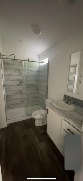 Bathroom with vanity, toilet, wood-type flooring, and walk in shower