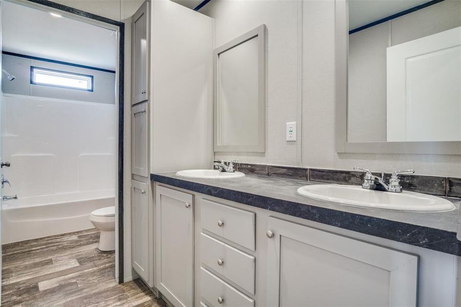 Full bathroom with shower / tub combination, vanity, toilet, and hardwood / wood-style flooring