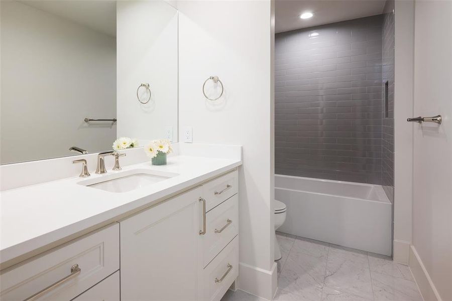Full bathroom featuring tile floors, tiled shower / bath combo, vanity, and toilet