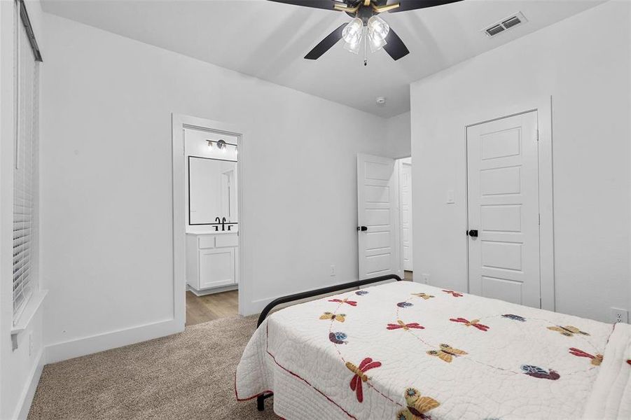 Carpeted bedroom featuring ceiling fan and sink