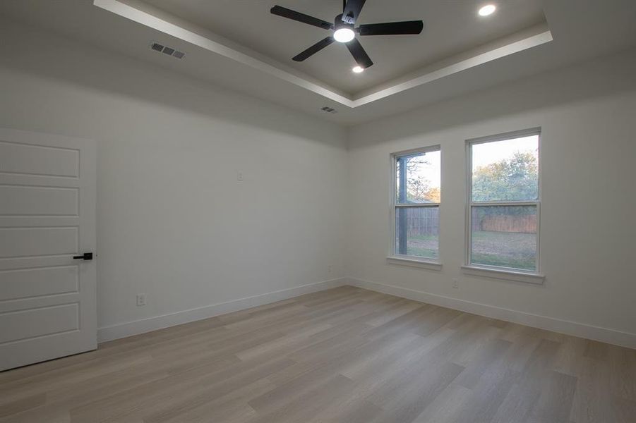 Living room featuring a high ceiling, ceiling fan, and light wood-type flooring