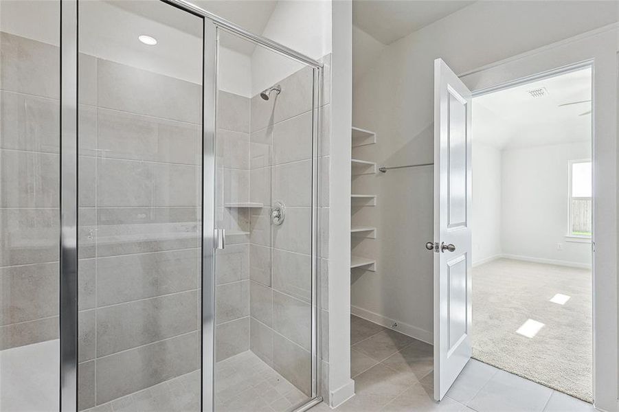 Bathroom featuring tile patterned flooring and a shower with shower door