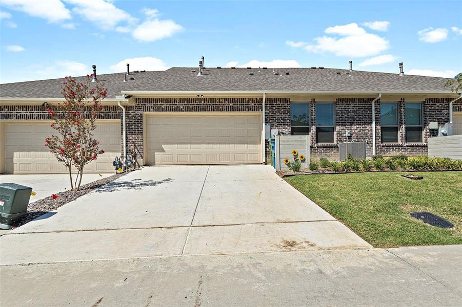 Ranch-style house featuring central AC unit, a garage, and a front yard