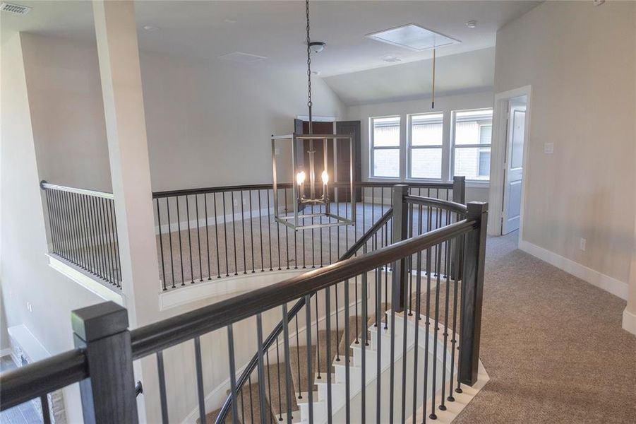 Staircase featuring vaulted ceiling and carpet floors