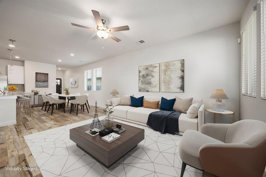 This living room is truly a Great Room, designed to impress with its striking EVP floors, sophisticated neutral palette, and soaring high ceilings. The elegant ceiling fan with integrated lighting adds both style and comfort, while expansive windows offer a picturesque view of your lush backyard—perfect for watching the kids or pets play while you relax in comfort.