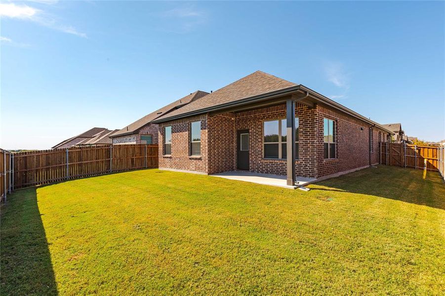 Back of property with a yard and a patio area