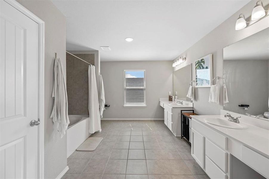 Bathroom featuring double vanity, tile patterned flooring, and shower / bathtub combination with curtain