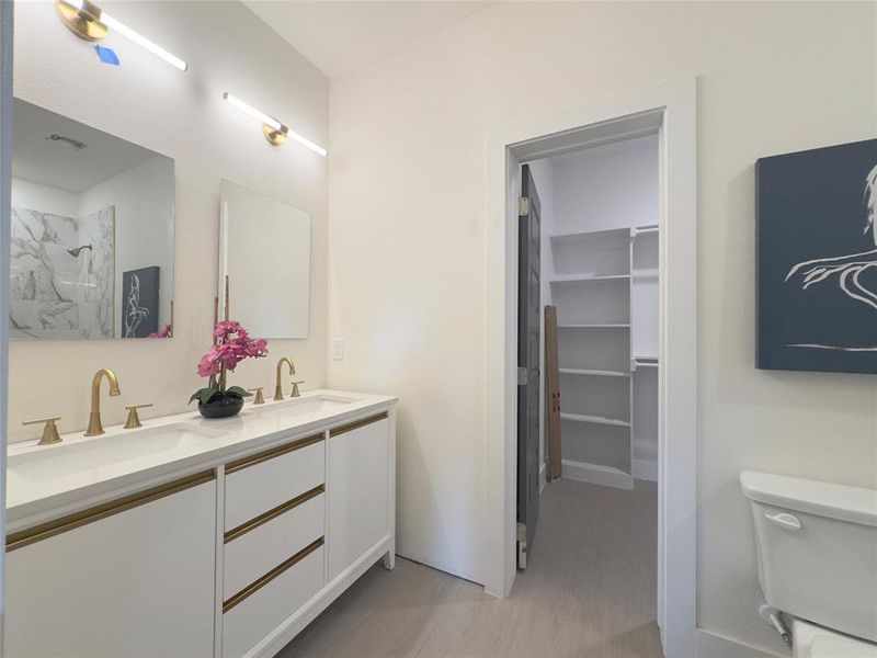 Bathroom featuring vanity, toilet, hardwood / wood-style flooring, and a shower